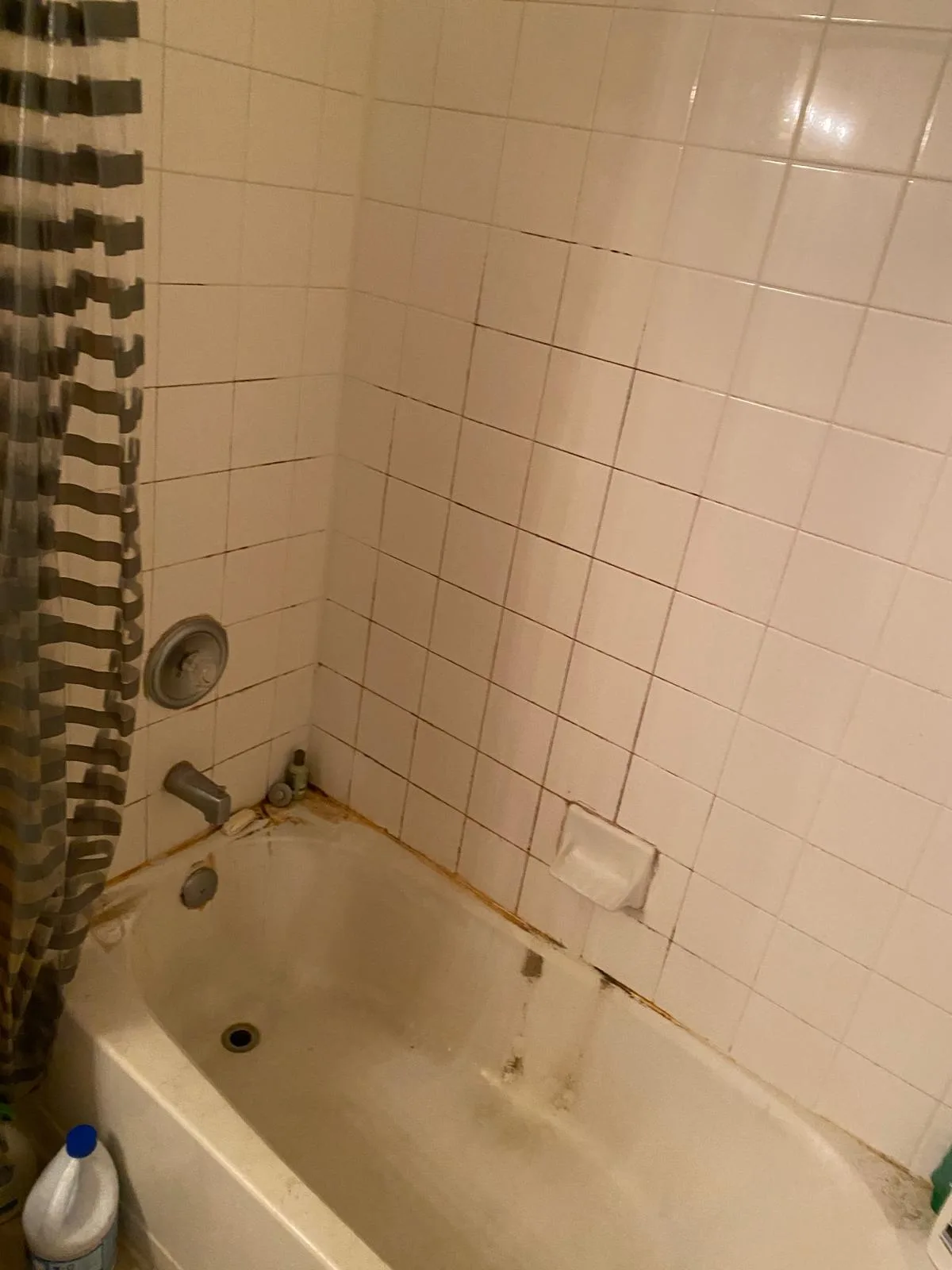 Bathtub before deep cleaning with soap scum and grime