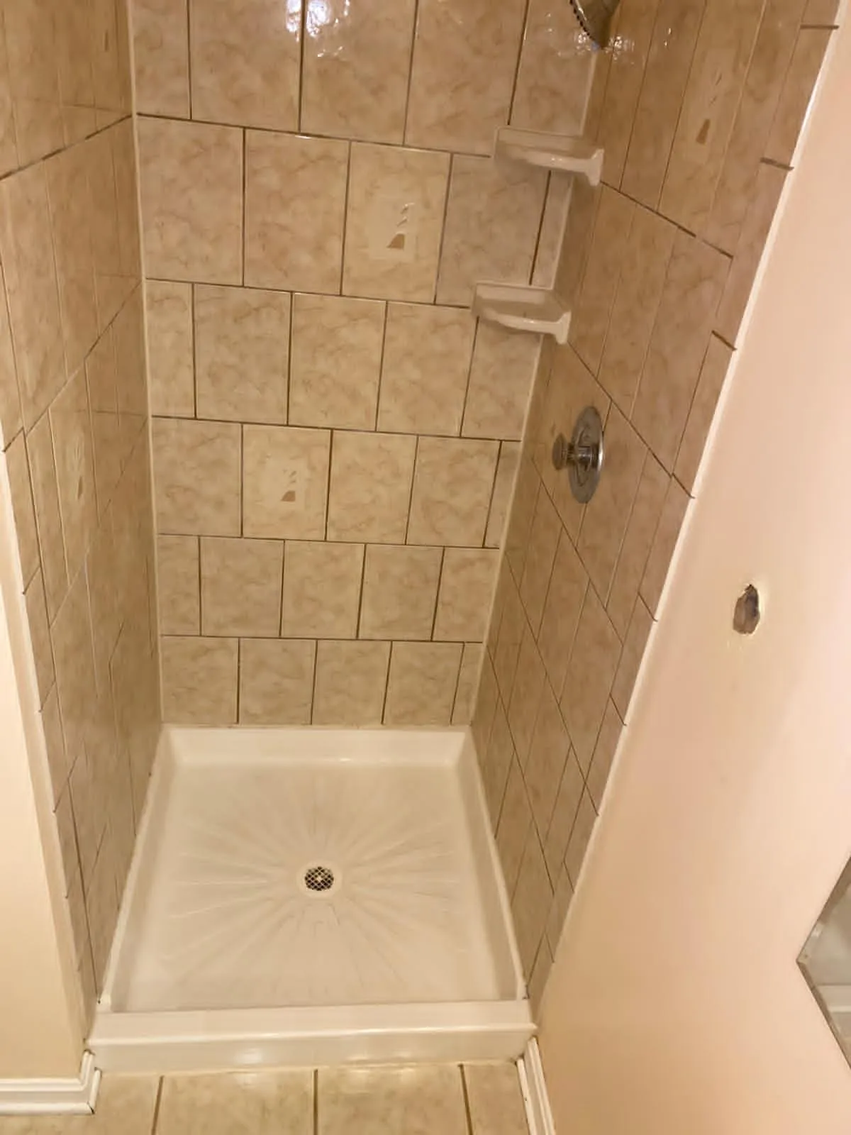 Tiled shower stall scrubbed with the pan bright