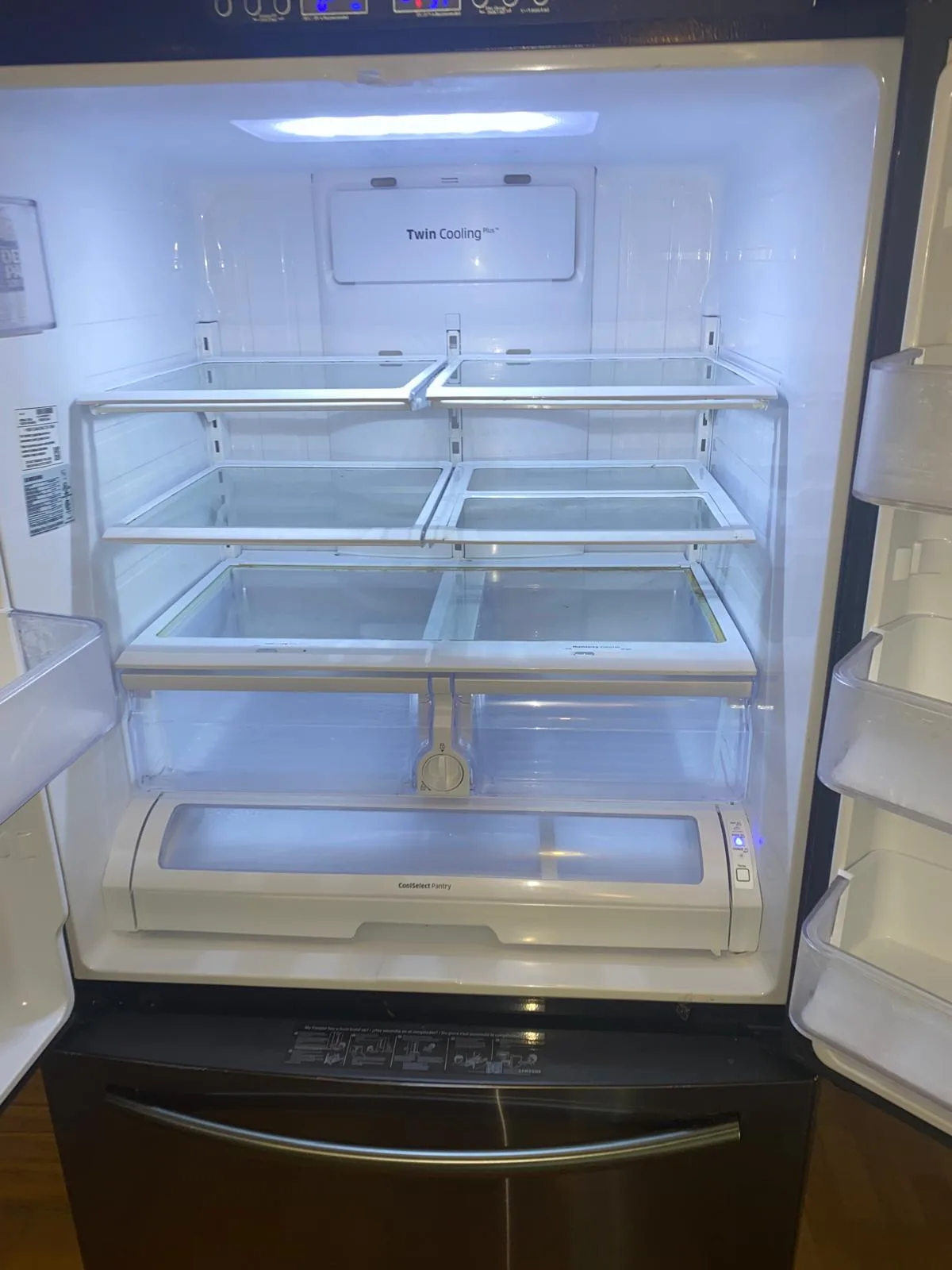 Refrigerator interior emptied and wiped shelf by shelf