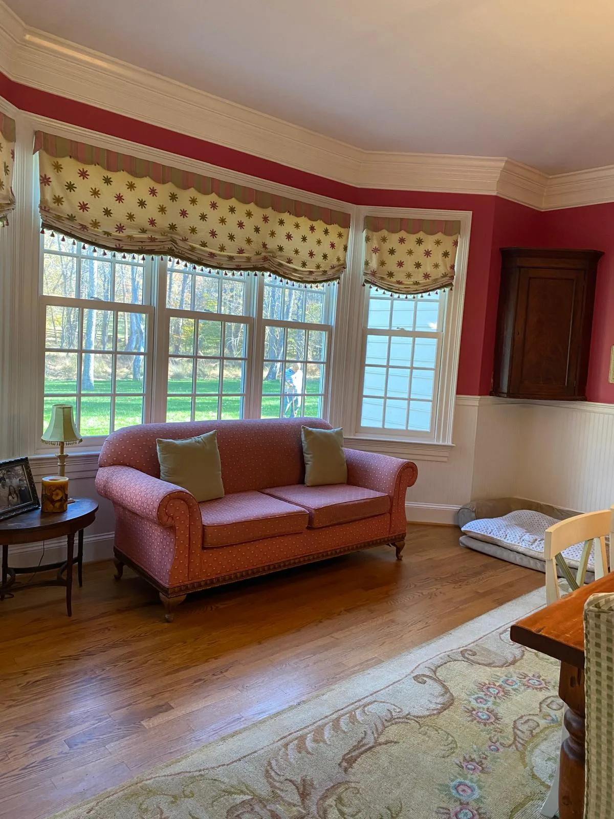 Sunlit living room with hardwood floors cleaned and rug straightened